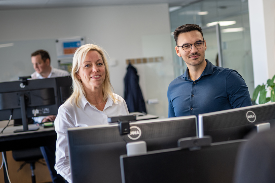 Two Terma employees smiling in an office.