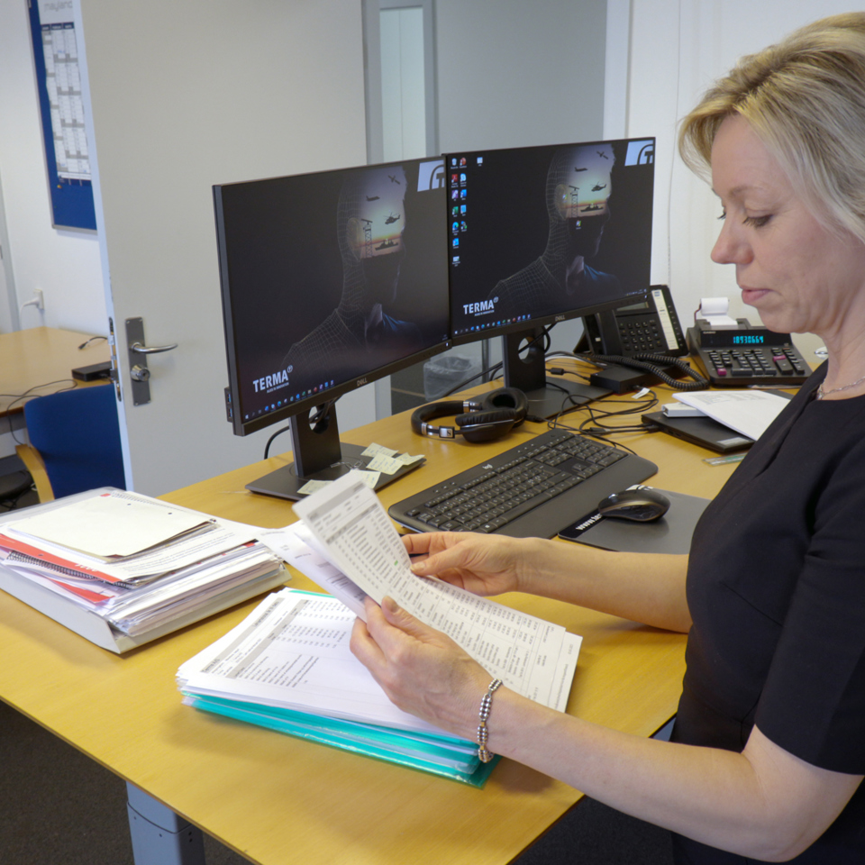 Woman looking at papers by her desk.