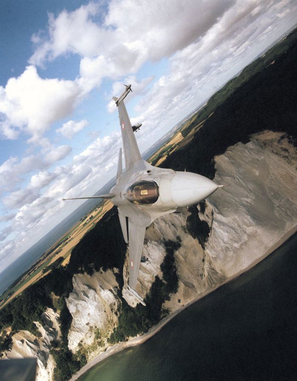 F-16 Fighting Falcon aircraft flying by Moens Klint in Denmark.