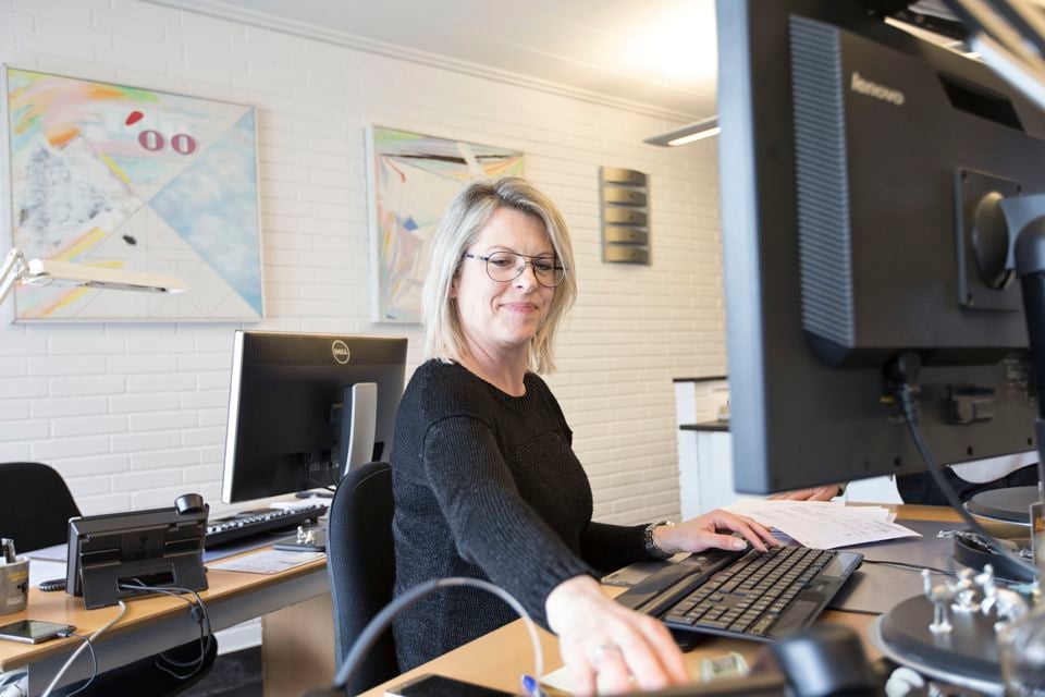 Terma employee working at a desk and smiling.