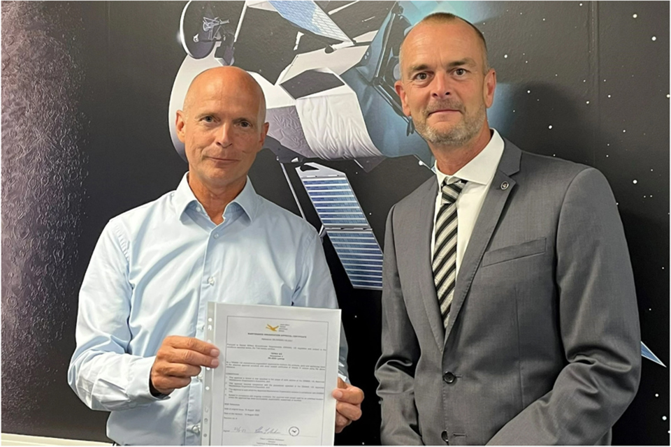 Two Terma employees holding a certificate.